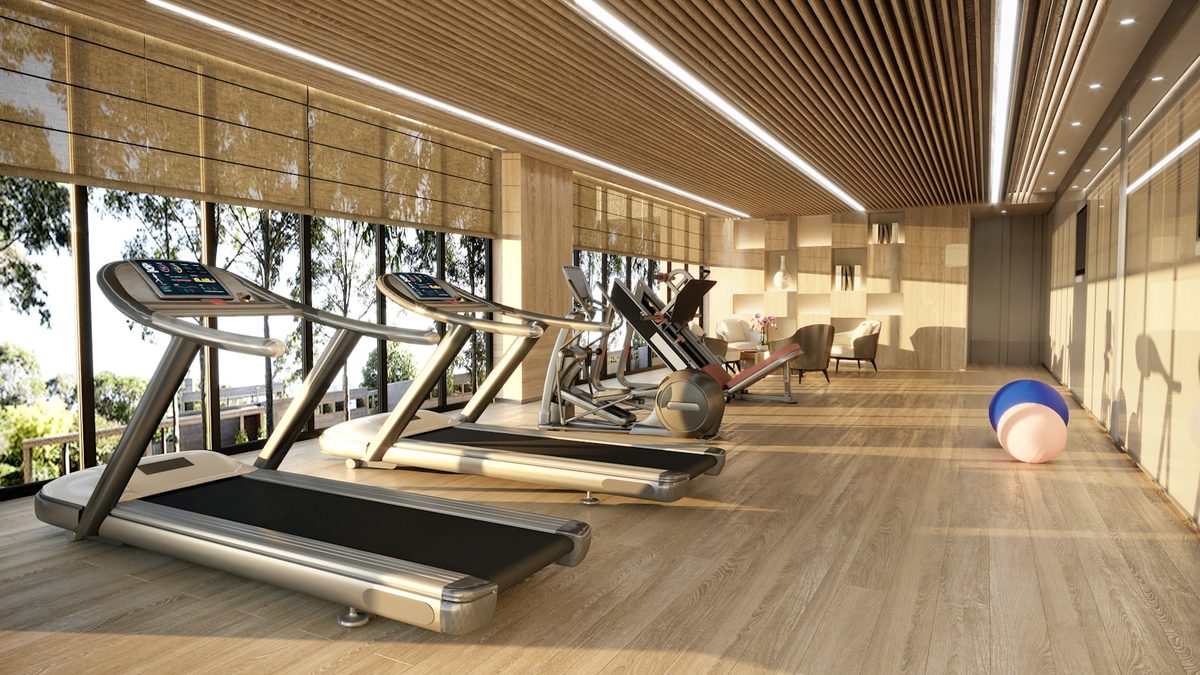 Interior de academia com equipamentos de musculação e pessoas treinando